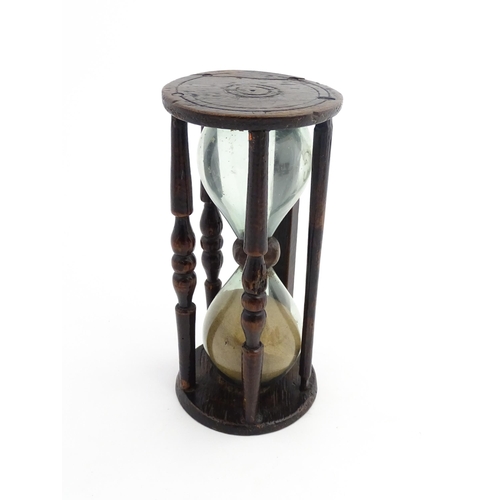 1185 - Treen : A 19thC sand timer, the wooden frame with turned uprights. Approx. 7 3/4