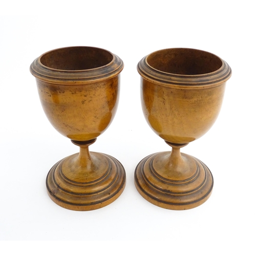 1186 - Treen : A pair of 19thC walnut goblets with banded detail. Approx. 6 1/4