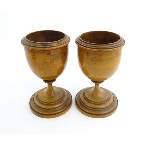 1186 - Treen : A pair of 19thC walnut goblets with banded detail. Approx. 6 1/4