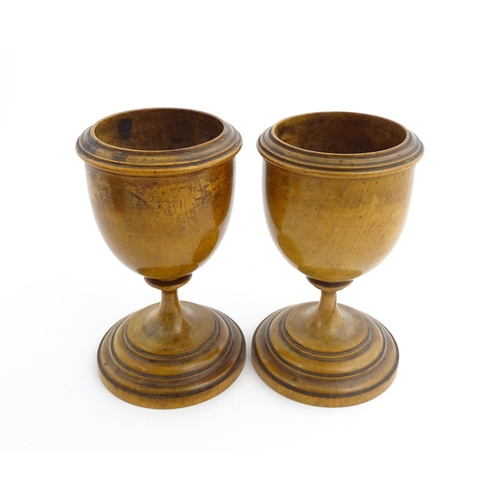 1186 - Treen : A pair of 19thC walnut goblets with banded detail. Approx. 6 1/4