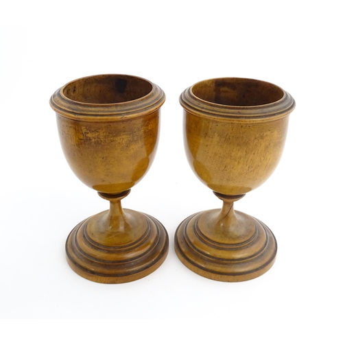 1186 - Treen : A pair of 19thC walnut goblets with banded detail. Approx. 6 1/4