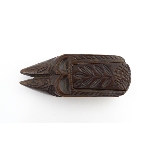 1203 - Treen : A 19thC double shoe snuff box modelled as a pair of shoes with sliding top and carved decora... 