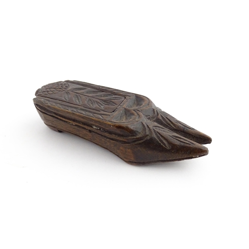 1203 - Treen : A 19thC double shoe snuff box modelled as a pair of shoes with sliding top and carved decora... 