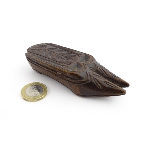 1203 - Treen : A 19thC double shoe snuff box modelled as a pair of shoes with sliding top and carved decora... 