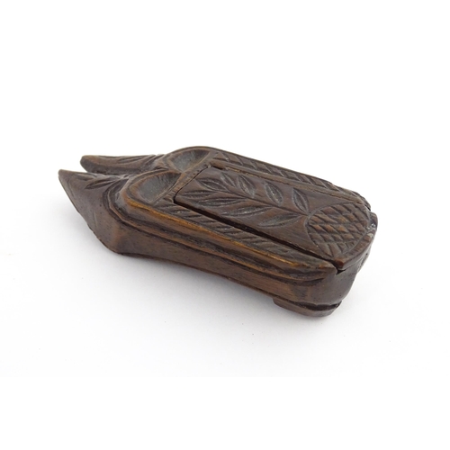 1203 - Treen : A 19thC double shoe snuff box modelled as a pair of shoes with sliding top and carved decora... 