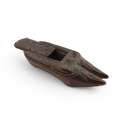 1203 - Treen : A 19thC double shoe snuff box modelled as a pair of shoes with sliding top and carved decora... 