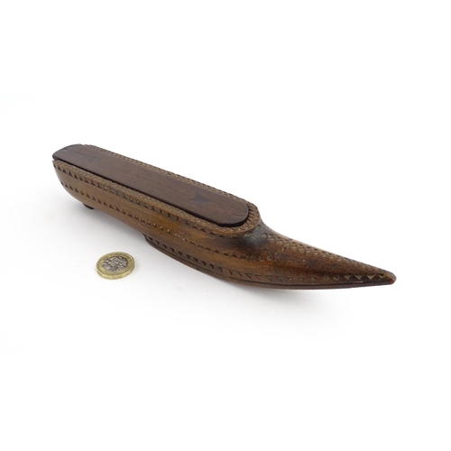 1212 - Treen : A 19thC carved wooden box of large shoe snuff form with chip carved decoration and sliding t... 