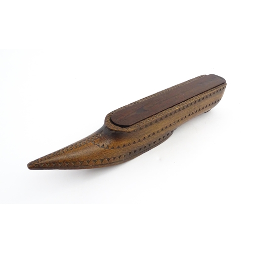 1212 - Treen : A 19thC carved wooden box of large shoe snuff form with chip carved decoration and sliding t... 