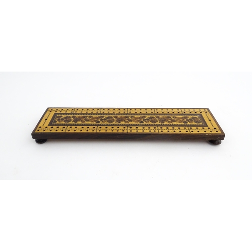 1214 - Treen: Three Tunbridge ware cribbage boards with central floral decoration. Largest approx. 10