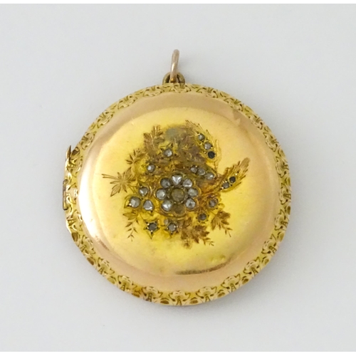 605 - A yellow gold pendant locket of circular form with foliate border and central floral detail set with... 