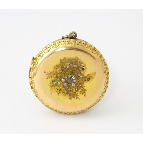 605 - A yellow gold pendant locket of circular form with foliate border and central floral detail set with... 