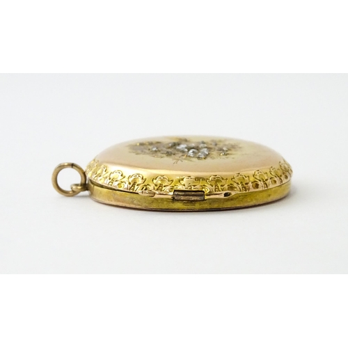 605 - A yellow gold pendant locket of circular form with foliate border and central floral detail set with... 