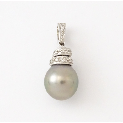 606 - An 18ct white gold pendant set with diamonds and a grey pearl. Approx. 1