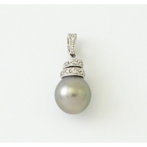 606 - An 18ct white gold pendant set with diamonds and a grey pearl. Approx. 1