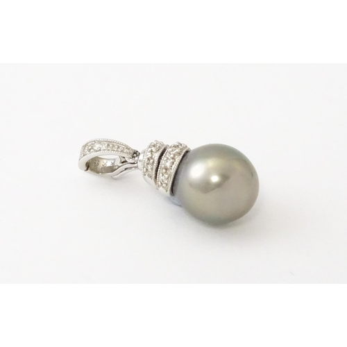 606 - An 18ct white gold pendant set with diamonds and a grey pearl. Approx. 1