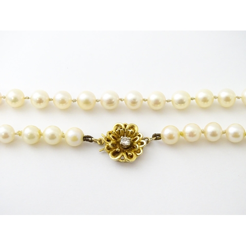 607 - A pearl necklace with 9ct gold clasp set with diamond. Approx. 20