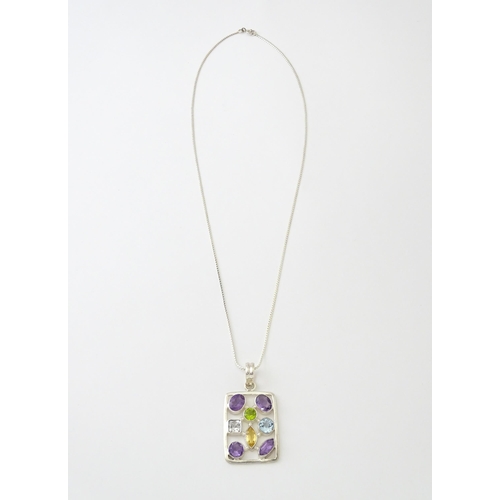 612 - A silver pendant set with coloured stones, with silver chain. Pendant approx. 2