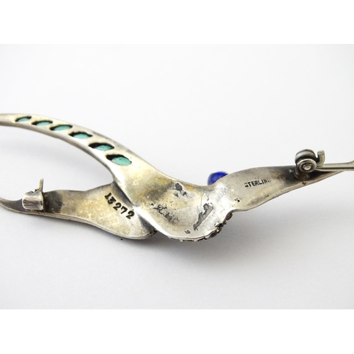 615 - A silver brooch modelled a pheasant in flight with guilloche enamel decoration and coloured stones, ... 