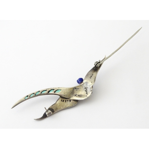 615 - A silver brooch modelled a pheasant in flight with guilloche enamel decoration and coloured stones, ... 