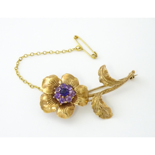 616 - A 9ct gold brooch of flower form set with central amethyst bordered by 7 further amethysts in a clus... 