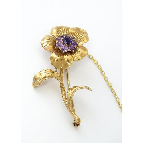 616 - A 9ct gold brooch of flower form set with central amethyst bordered by 7 further amethysts in a clus... 