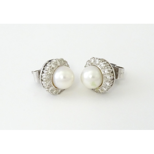 620 - A pair of 18ct white gold stud earrings with central cultured pearl bordered by 14 brilliant cut dia... 