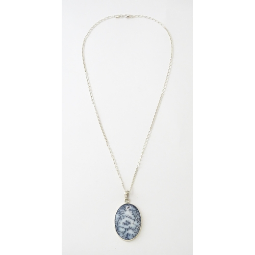 621 - A silver pendant set with dendrite agate, with a silver chain. Pendant approx. 2