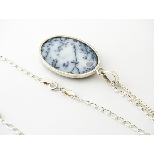 621 - A silver pendant set with dendrite agate, with a silver chain. Pendant approx. 2