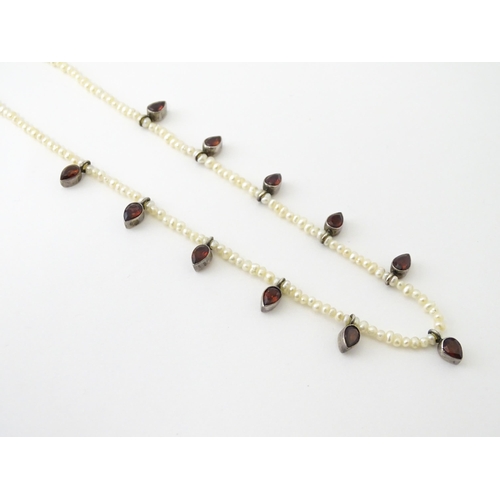 625 - A pearl choker necklace set with garnet with a yellow metal clasp. Approx. 14