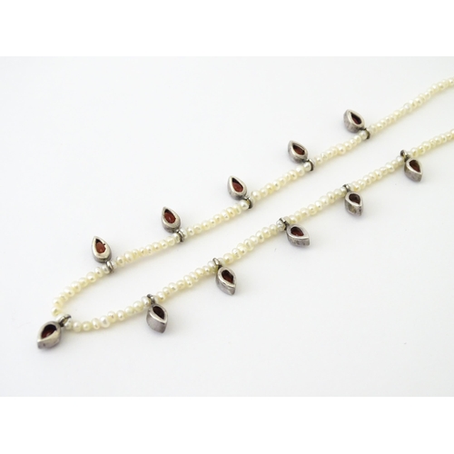 625 - A pearl choker necklace set with garnet with a yellow metal clasp. Approx. 14