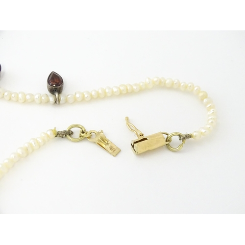 625 - A pearl choker necklace set with garnet with a yellow metal clasp. Approx. 14