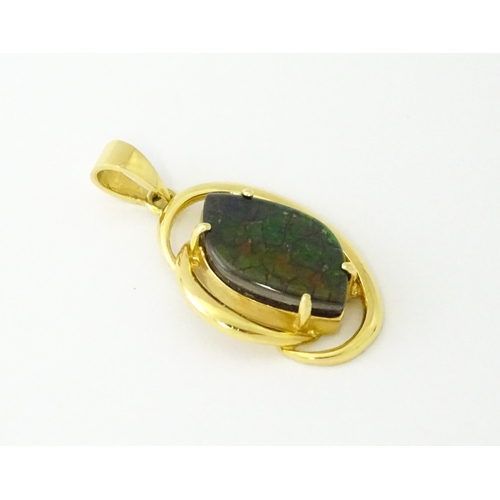 627 - A gold pendant set with ammolite. Approx. 1