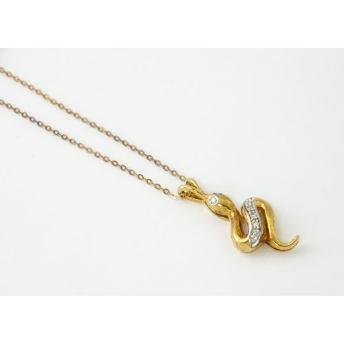 628 - A 9ct gold pendant of snake / serpent form set with diamonds, on a 9ct gold chain. Pendant approx. 1... 