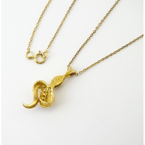 628 - A 9ct gold pendant of snake / serpent form set with diamonds, on a 9ct gold chain. Pendant approx. 1... 