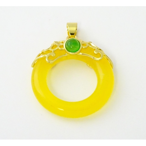 629 - A pendant with gilt metal mounts and yellow coloured jade like ring detail. Approx. 1 1/4