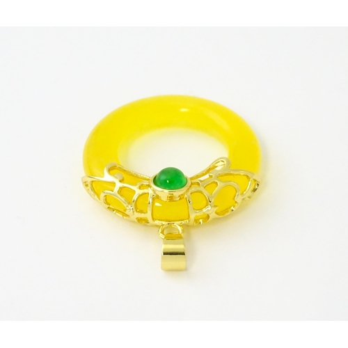 629 - A pendant with gilt metal mounts and yellow coloured jade like ring detail. Approx. 1 1/4