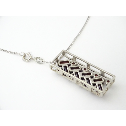 636 - A silver pendant set with garnets, on a silver chain. Pendant approx. 1 1/4