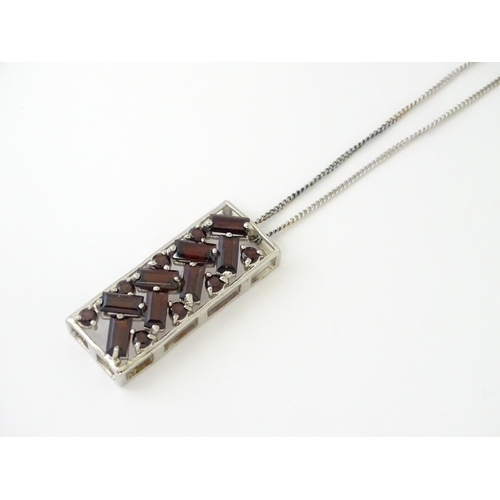 636 - A silver pendant set with garnets, on a silver chain. Pendant approx. 1 1/4