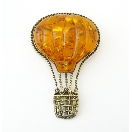 679 - A gilt metal brooch unusually formed as a hot air balloon, the balloon section with amber detail. Ap... 