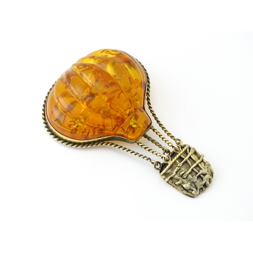 679 - A gilt metal brooch unusually formed as a hot air balloon, the balloon section with amber detail. Ap... 