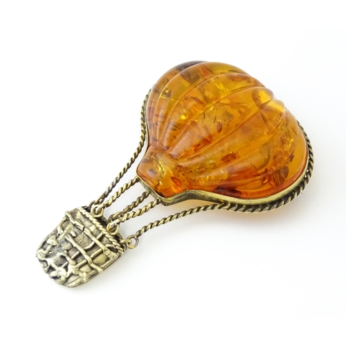 679 - A gilt metal brooch unusually formed as a hot air balloon, the balloon section with amber detail. Ap... 