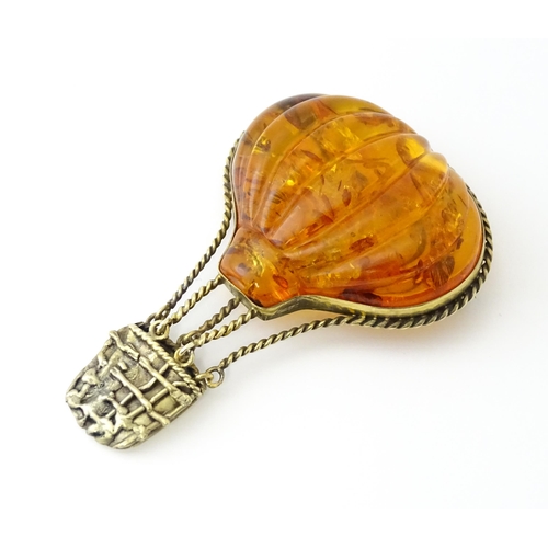 679 - A gilt metal brooch unusually formed as a hot air balloon, the balloon section with amber detail. Ap... 