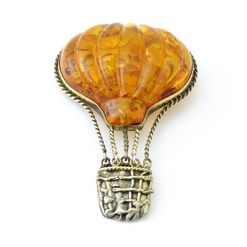 679 - A gilt metal brooch unusually formed as a hot air balloon, the balloon section with amber detail. Ap... 