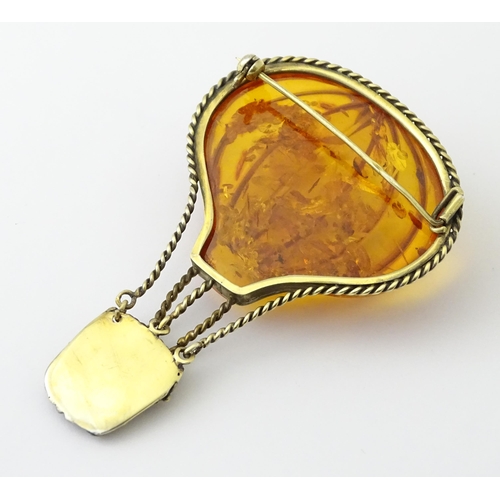 679 - A gilt metal brooch unusually formed as a hot air balloon, the balloon section with amber detail. Ap... 