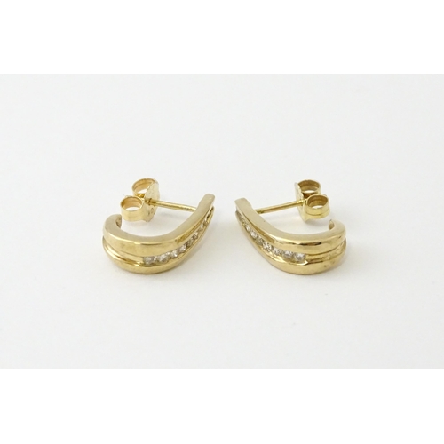 680 - A pair of 9ct gold earrings with channel set diamonds. Approx. 3/4