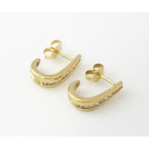 680 - A pair of 9ct gold earrings with channel set diamonds. Approx. 3/4