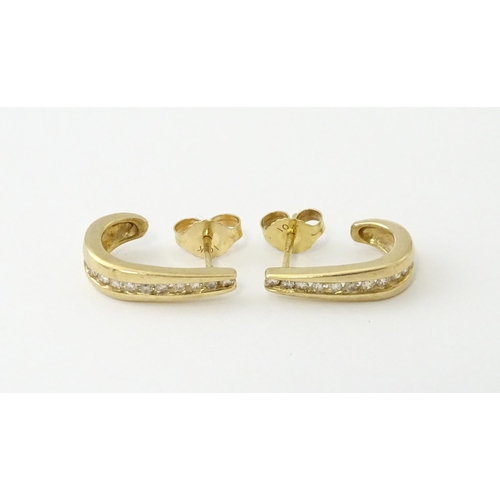 680 - A pair of 9ct gold earrings with channel set diamonds. Approx. 3/4