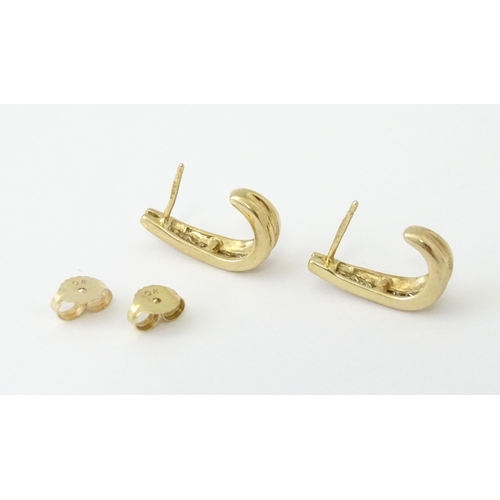 680 - A pair of 9ct gold earrings with channel set diamonds. Approx. 3/4