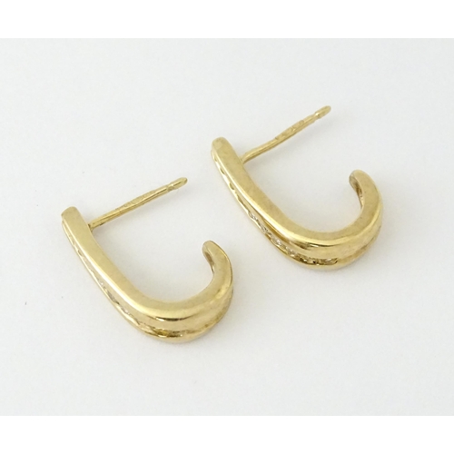 680 - A pair of 9ct gold earrings with channel set diamonds. Approx. 3/4