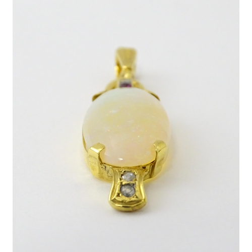 683 - A 14ct gold pendant set with central opal cabochon with diamonds and ruby in an Art Deco style setti... 